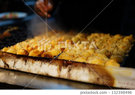 Scene of takoyaki being grilled in front of a takoyaki shop 132398496