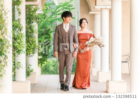 Wedding reception, after-party, bride and groom appearing in wedding color dresses, dressed-up couple 132398511