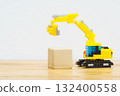 A toy excavator lifting wooden blocks 132400558