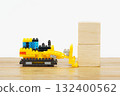 A toy construction scene in which a small bulldozer pushes wooden blocks 132400562