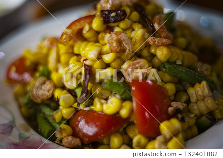 Thai Spicy Corn Salad With Salted Egg And Dried Shrimp, A vibrant Thai spicy corn salad with salted egg and dried shrimp bursts with color on table, perfect for a savory photo or a visual display. 132401082
