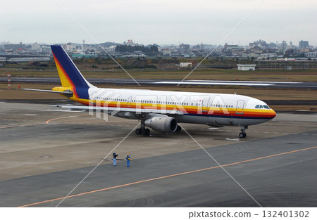 地勤人員向起飛的飛機揮手致意 地勤人員向起飛的飛機揮手致意 132401302