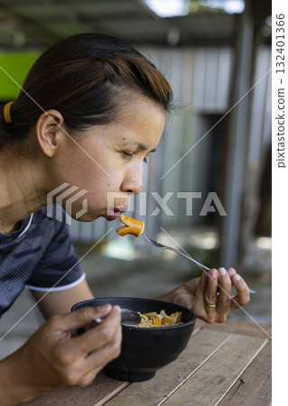 Woman Is Eating Instant Noodles, Tom Yum Kung Flavor, cozy mealtime scene perfect for food ads, culinary campaigns, lifestyle visuals, and quick meal promotions. Woman Is Eating Instant Noodles, Tom Yum Kung Flavor, cozy mealtime scene perfect for food ads, culinary campaigns, lifestyle visuals, and quick meal promotions. 132401366