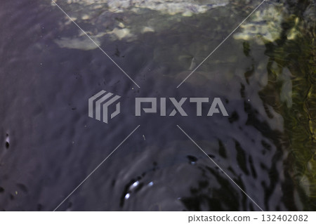 Ripples On Water Surface In Basin, Gentle ripples dance on a water surface in a basin, light reflecting off each wave, perfect for a nature photography shot or a serene water showcase. 132402082