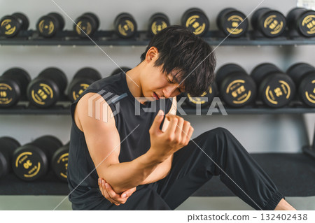 Young Asian man suffering from elbow pain while training at the gym 132402438