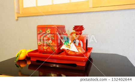 日式房間的障子窗前擺放著新年用的土爐、禦節料理的多層盒子和帶葉子的橘子（4482） 132402644