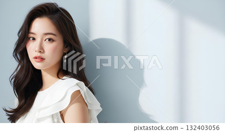 Portrait of a young woman with long hair and white clothes smiling in natural light 132403056