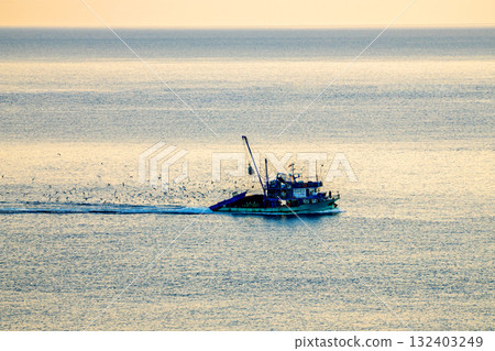 A fishing boat returning from a hunt in the Black Sea with seagulls A fishing boat returning from a hunt in the Black Sea with seagulls 132403249