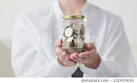 Asian woman's hand holding a jar full of money Asian woman's hand holding a jar full of money 132403630