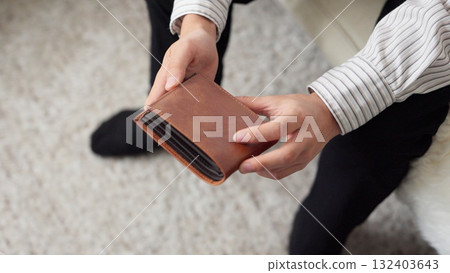 檢查他的錢包。一個沒有錢的窮學生。 檢查他的錢包。一個沒有錢的窮學生。 132403643