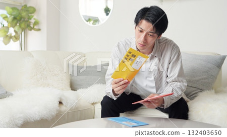 亞洲男子正在查看催款通知單 132403650