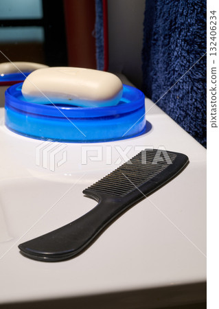 comb and hairbrush on the bathroom sink comb and hairbrush on the bathroom sink 132406234
