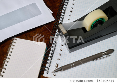 office envelope, spiral notebook, adhesive tape and ballpoint pens 132406245