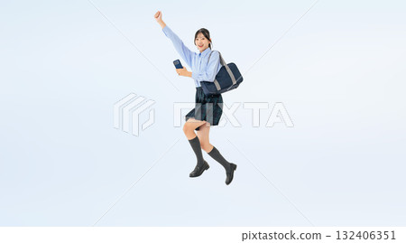 身穿制服的女學生拿著智慧型手機跳躍的全身照片 132406351