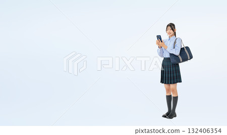 Full-body photo of a female student in uniform using a smartphone Full-body photo of a female student in uniform using a smartphone 132406354