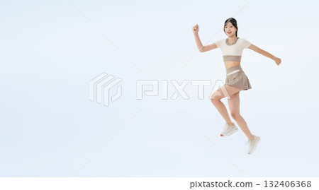 Full-body photo of a woman in sportswear jumping Full-body photo of a woman in sportswear jumping 132406368