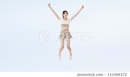 Full-body photo of a woman in sportswear jumping Full-body photo of a woman in sportswear jumping 132406372