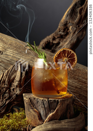 An old-fashioned cocktail over ice on an old wooden stump. 132406386