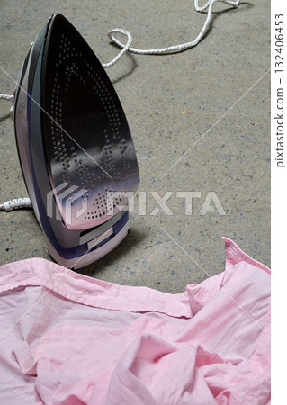 an iron and shirts on table 132406453