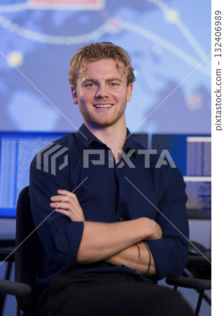 Confident young professional in control room with technology background 132406989