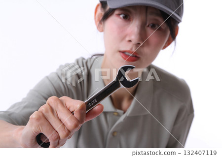 A woman working with a wrench A woman working with a wrench 132407119