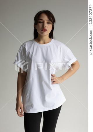 White Tshirt mockup, Woman modeling plain white Tshirt in neutral studio setting for branding White Tshirt mockup, Woman modeling plain white Tshirt in neutral studio setting for branding 132407874