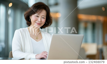 A woman operating a computer with a smile A woman operating a computer with a smile 132408079