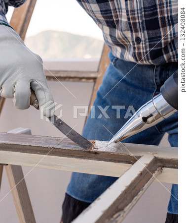 Carpenter at work, restoring an old wooden window. Carpentry. 132408084