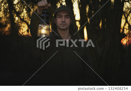 Male portrait in military clothing in a night forest with antique lamp Male portrait in military clothing in a night forest with antique lamp 132408254