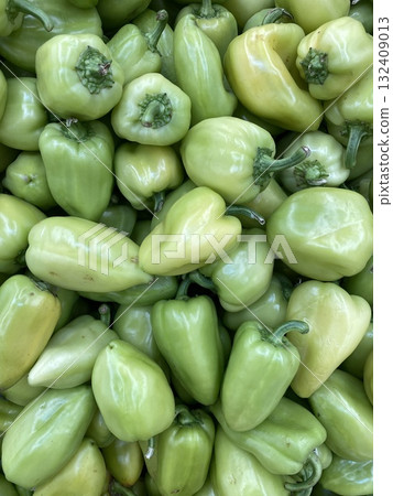 Green bell peppers piled together in abundance make a seamless food background Green bell peppers piled together in abundance make a seamless food background 132409013