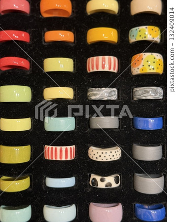 Colorful ceramic rings arranged in grid pattern, showcasing variety of artistic designs Colorful ceramic rings arranged in grid pattern, showcasing variety of artistic designs 132409014