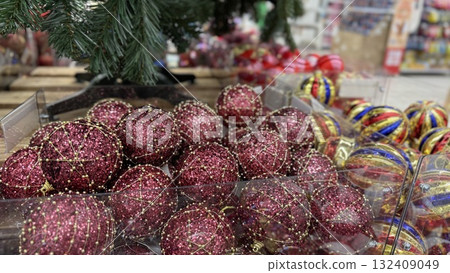 Christmas ornaments in store display with variety of festive decorations and background Christmas ornaments in store display with variety of festive decorations and background 132409049