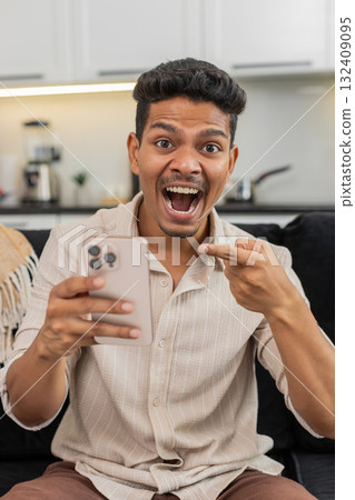 Indian man watches wow video reacts with shock eyes laughs shares link to friends in messenger chat Indian man watches wow video reacts with shock eyes laughs shares link to friends in messenger chat 132409095