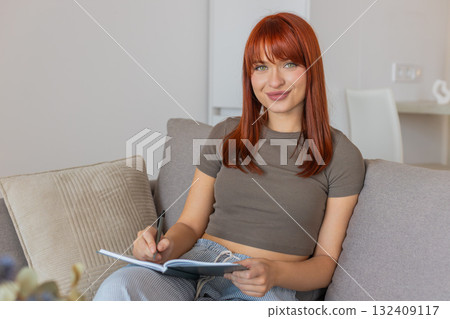 Young woman writes in notebook plans key decisions creates schedule and task list for next actions 132409117