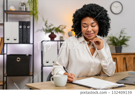 African American businesswoman signs important documents nods satisfied closing big successful deal African American businesswoman signs important documents nods satisfied closing big successful deal 132409139
