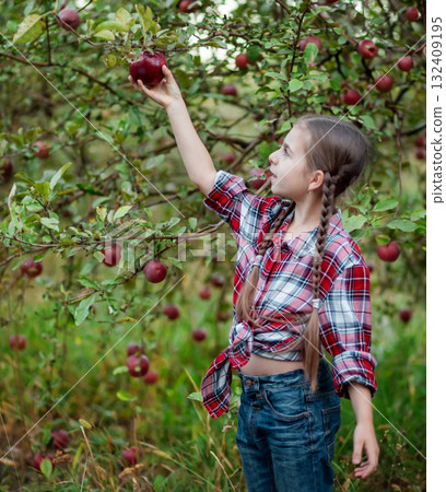 Beautiful girl apple in organic apples in orchard. Girl eating organic apple in garden 132409195