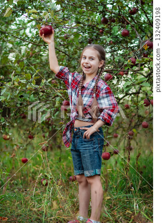 Beautiful girl apple in organic apples in orchard. Girl eating organic apple in garden 132409198
