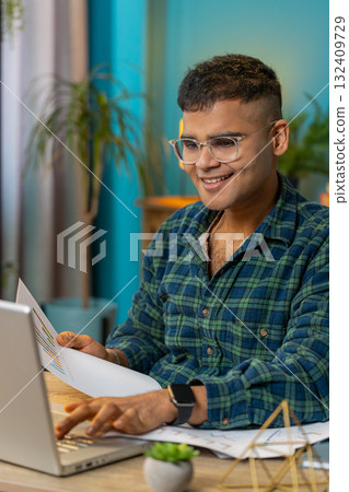 Freelancer man accountant works with financial graph documents calculate taxes for charts at office 132409729