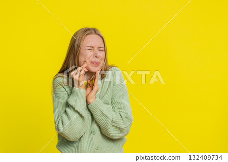 Woman touching cheek closing eyes with expression of terrible suffer from painful toothache Woman touching cheek closing eyes with expression of terrible suffer from painful toothache 132409734