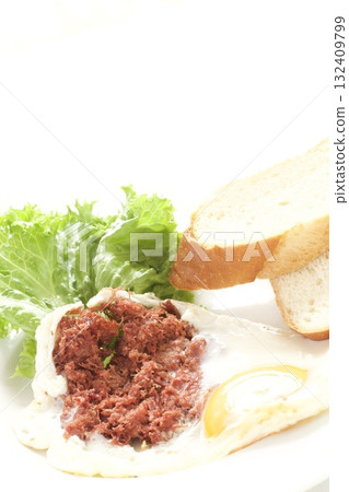 Breakfast: fried eggs, corned beef, and French bread Breakfast: fried eggs, corned beef, and French bread 132409799