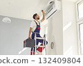 Expert Technician Maintaining Home Air Conditioner 132409804