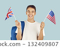 Happy student boy with backpack and British and American flags learning English language 132409807