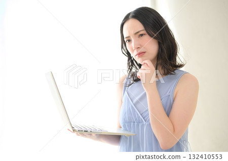 A woman troubled watching a personal computer A woman troubled watching a personal computer 132410553