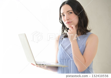A woman troubled watching a personal computer A woman troubled watching a personal computer 132410556