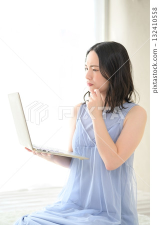 A woman troubled watching a personal computer 132410558