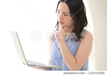 A woman troubled watching a personal computer A woman troubled watching a personal computer 132410560