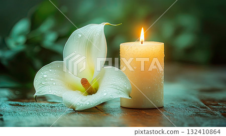 A white lilies calla flower with water droplets beside lit candle, evoking emotion and memory. Funeral symbol A white lilies calla flower with water droplets beside lit candle, evoking emotion and memory. Funeral symbol 132410864