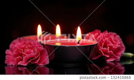 Beautiful red roses and candle on table against black background. Funeral symbol. Burning candle placed between two white roses dark surface, symbolizing remembrance. 132410868