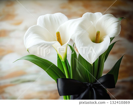 Beautiful bouquet of white calla lilies against a textured black background. Funeral symbol 132410869