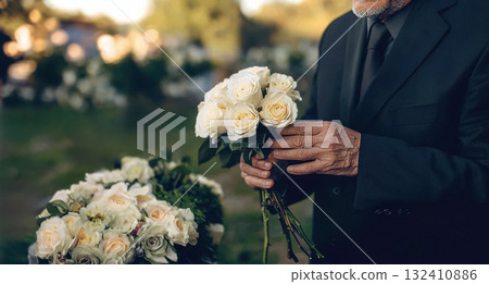 Man in black suit holding bouquet of white roses, symbolizing mourning or tribute. Mature man in black suit holding one fresh white rose Man in black suit holding bouquet of white roses, symbolizing mourning or tribute. Mature man in black suit holding one fresh white rose 132410886